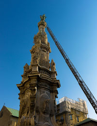 Low angle view of crane obelisco dell immacolata against clear blue sky