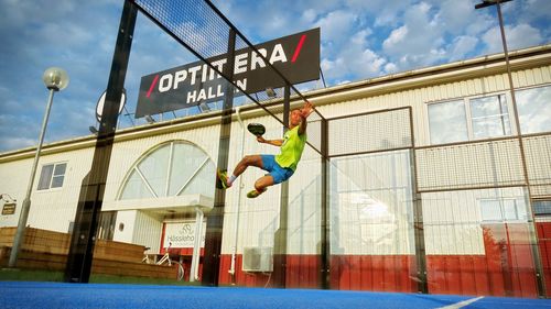 Low angle view of man jumping against the sky