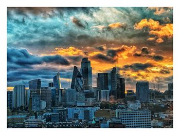 Modern buildings in city against sky during sunset