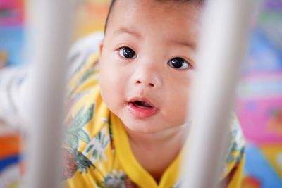 High angle portrait of cute baby girl kneeling in crib