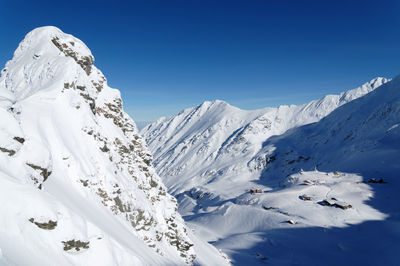 Scenic view of snowcapped mountains against clear blue sky