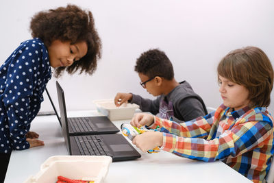 Students in school computer coding class building and learning to program robot vehicle. multi