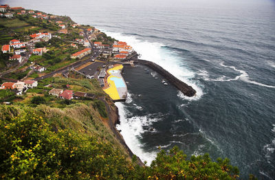 High angle view of residential buildings on mountain by sea