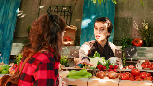 Portrait of young woman holding food at restaurant