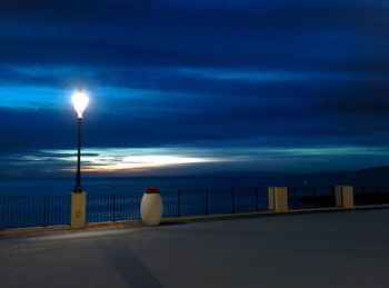 View of illuminated street light against cloudy sky