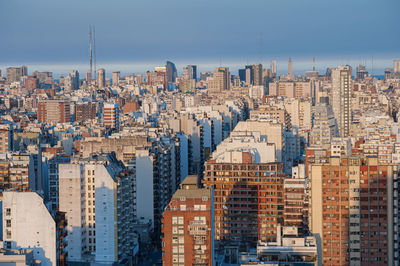 Aerial view of buildings in city against clear sky