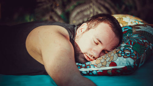 Portrait of young man sleeping on bed in the woods.