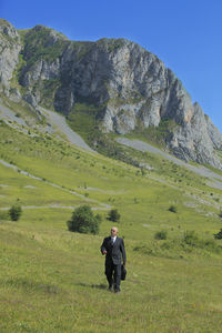 Businessman walking on hill