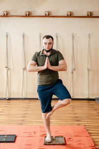 Full length portrait of man standing against wall