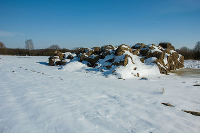 Scenic view of snow covered land against blue sky