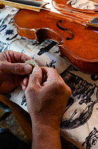 Violin maker luthier changing bridge of a handmade baroque violin