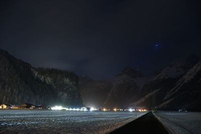 Scenic view of illuminated mountains against sky at night