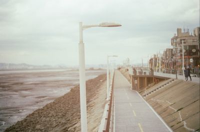 Road by city against sky