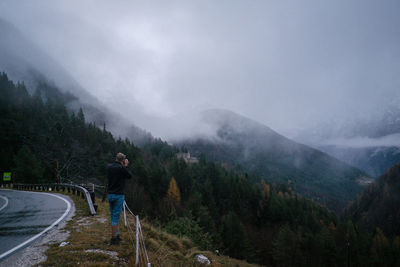 Man standing on mountain against sky