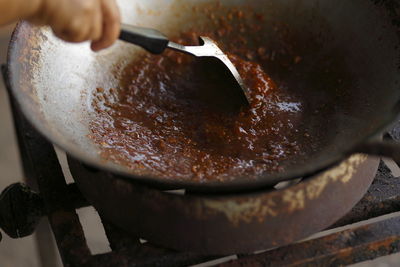 Cooking thai cuisine, preparing curry paste on a hot wok frying pan 