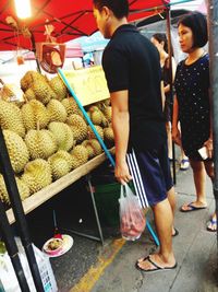 Rear view of woman standing at market stall