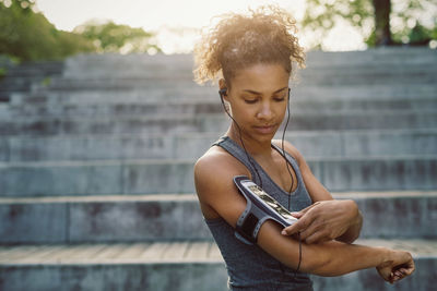 Woman using smart phone armband while exercising