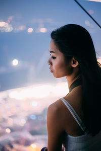 Mid adult woman against sky at dusk