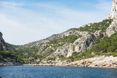 Scenic view of sea and mountains against sky