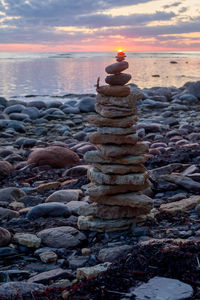 Stack of stones on beach during sunset