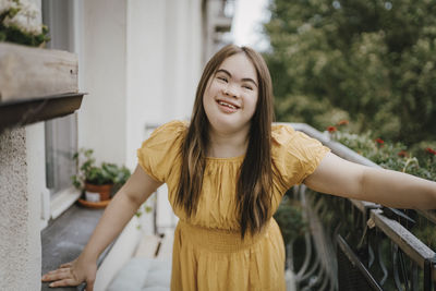 Smiling woman with down syndrome standing in balcony