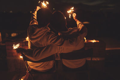 Man and woman with fire crackers at night
