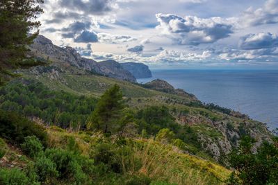 Scenic view of sea and mountains against sky