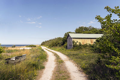 Empty road amidst plants against sky