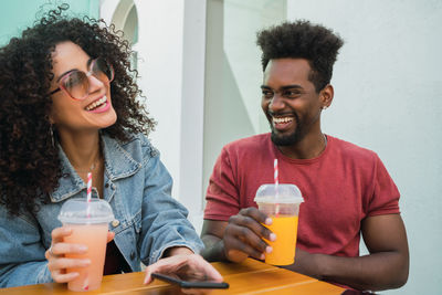 Portrait of happy young man drinking glass