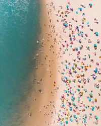 Drone shot of colorful parasols and people at beach during summer