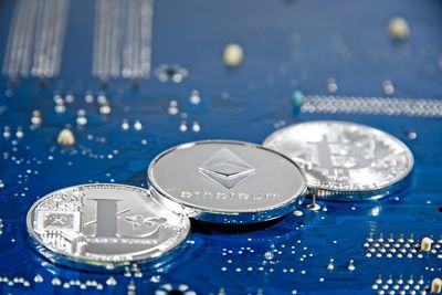 Close-up of various cryptocurrency on blue circuit board