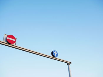 Low angle view of road sign against clear sky