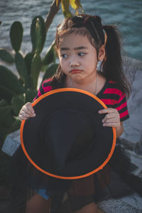 Girl holding witch hat looking away