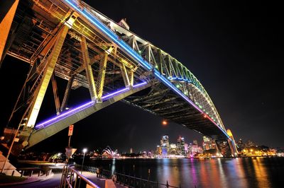 Low angle view of illuminated suspension bridge at night