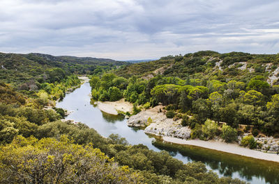 Scenic view of river amidst trees against sky