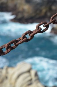 Close-up of chain against sea