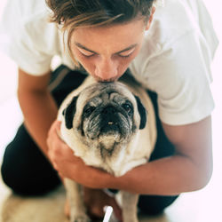 Teenage boy kissing pug