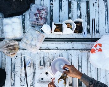 Directly above shot of hand holding takeout on table