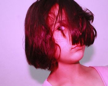 Close-up portrait of serious girl against wall