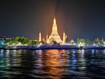 Illuminated building against sky with waterfront