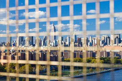 Reflection of buildings in river against blue sky