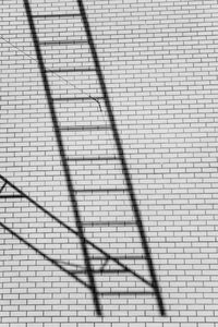 Low angle view of ladder on brick wall