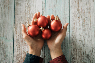 Cropped hand of woman holding apple on table