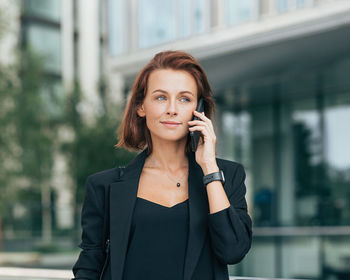 Young businesswoman talking on phone in city