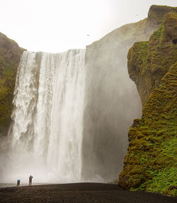 Icelandic waterfall. people in foreground.