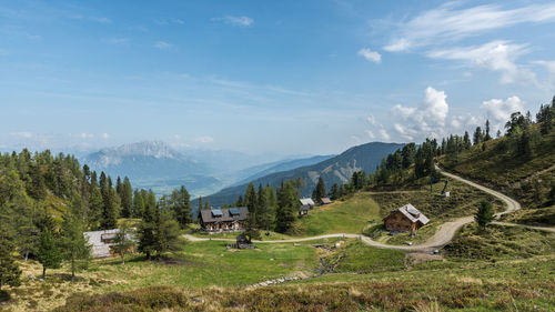 Scenic view of trees and mountains against blue sky