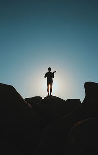 Silhouette of man standing on mountain against sky