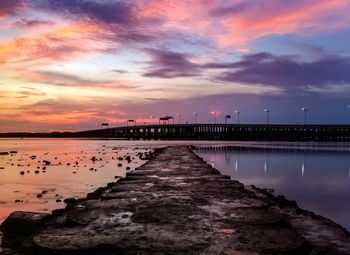 Pier on sea at sunset