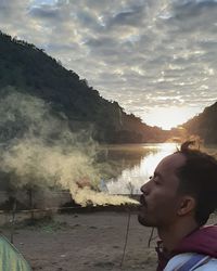 Portrait of young man in mountains against sky