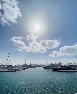 View of marina at harbor against cloudy sky